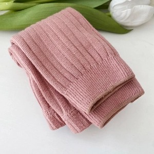 Close-up detail view of soft pink ribbed knit toddler tights, delicate texture and cozy fit.