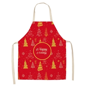 Detail of red linen Christmas apron with gold Happy Holidays print and tree patterns