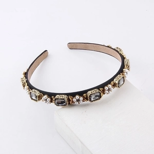 Detailed shot of retro headband with gray crystals and pearls on white stone