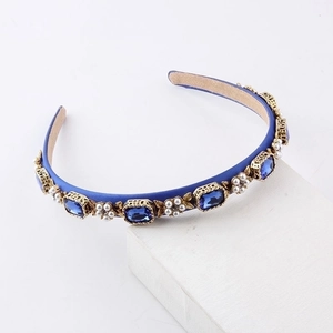 Detail of royal blue satin headband with rectangle blue rhinestones and pearl flower motifs