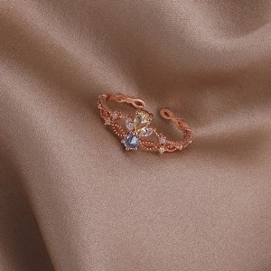 Macro shot of rose gold crown ring with pear-shaped yellow gems on silk fabric