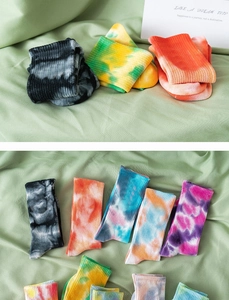 Detail of multi-color tie-dye cotton crew socks with ribbed cuffs in various vibrant patterns