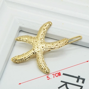 Detailed view of a 5.7cm golden starfish alloy hair clip with realistic bio-texture