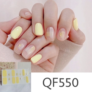 Detailed view of yellow daisy pattern nail stickers with gold foil accents on fingernails