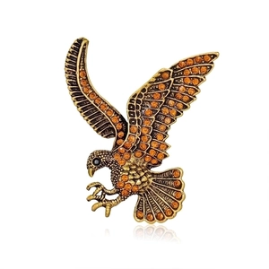 Detailed view of eagle brooch with bronze plating and brown rhinestones on white backdrop
