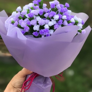 Dettaglio di fiori fatti a mano in carta velina viola e bianca con nastro rosa