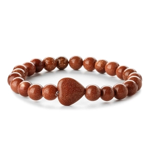 Close-up of brown goldstone beaded bracelet with a heart-shaped centerpiece on white background