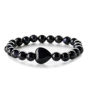 Macro detail of deep blue goldstone beaded bracelet with central heart-shaped stone