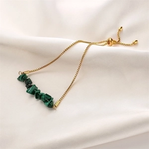Detail of adjustable gold box chain bracelet with green natural stone beads on silk