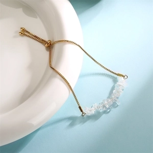 Detailed view of white crystal stones on an adjustable gold stainless steel bracelet