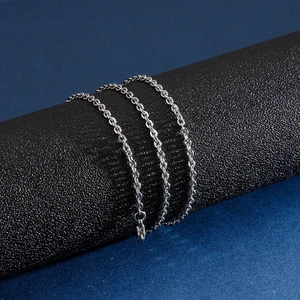 Polished silver stainless steel O-chain necklace wrapped on a textured black display