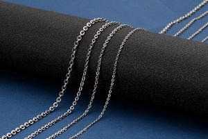 Detailed close-up of multiple silver stainless steel O-link chains in various thicknesses