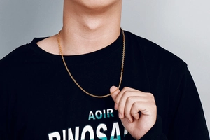 Close-up of gold stainless steel O-chain necklace worn on a black crew neck shirt