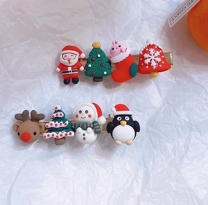 Christmas hair clips set with Santa, elk, and snowman charms on a gold metal base
