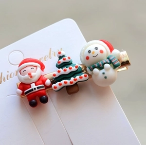 Detailed view of Santa, Christmas tree and snowman hair clips on a white display card