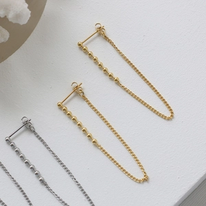 Detailed macro view of minimalist 18K plated titanium steel tassel chain earrings