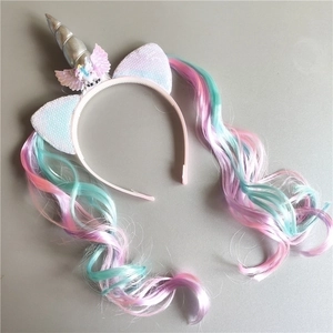 Close-up of unicorn headband with silver horn, pink wings and colorful hair extension