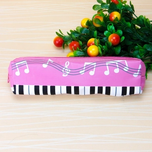 Detail view of pink music pencil case featuring white notes and piano key patterns