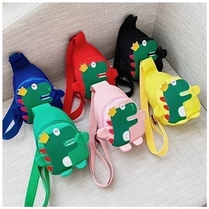 Detailed view of cute dinosaur crossbody bags for kids in six vibrant colors on a sofa