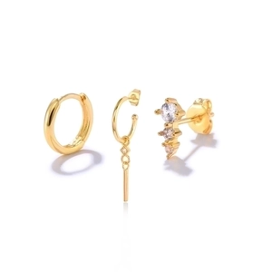 Detail of a 3-piece gold earring set featuring a stud with zircons and geometric pendants