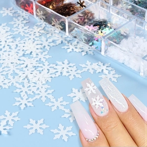 Detailed view of 12-grid Christmas snowflake nail sequins and glitter on fingernails