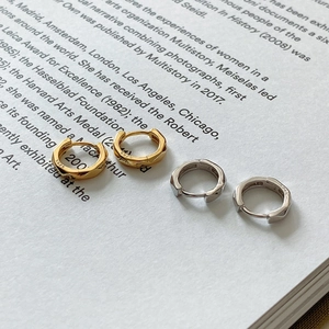 Detailed macro view of S925 sterling silver stamp on gold and silver faceted hoop earrings