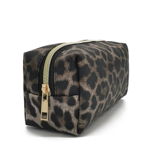 Detail of leopard print toiletry bag with premium gold zipper on a white background