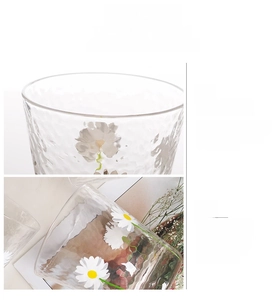 Close-up of glass rim and daisy pattern on textured hammer finish glass cup
