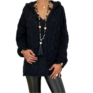 Detail of black cable-knit texture and oversized hood on a stylish knitted sweater dress