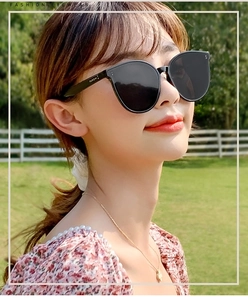 Close-up of black oversized sunglasses featuring stylish snake-shaped metal temple logo