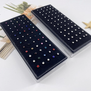 L-shaped stainless steel nose studs set with sparkling crystals in a display box