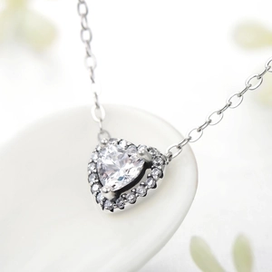 Elegant S925 silver heart necklace with sparkling zircon pendant on white ceramic base