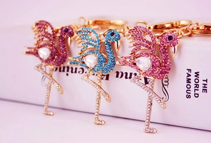 Close-up of golden flamingo keychains with purple, blue, and pink sparkling rhinestones
