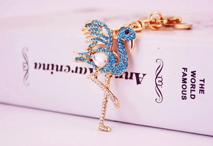 Detail shot of a crystal-encrusted flamingo keychain with blue rhinestones and a gold clasp