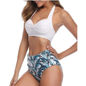 Side view of white halter bikini top and high-waisted tropical palm leaf print bottoms