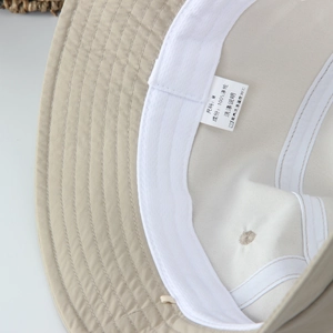 Quick-dry beige bucket hat interior details with sweatband and M size polyester wash label