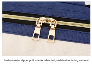 Close-up of premium dual golden metal zippers on a blue and white oxford diaper bag