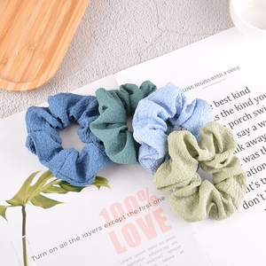 Elegant seersucker scrunchies in blue and green tones on a stylish magazine background