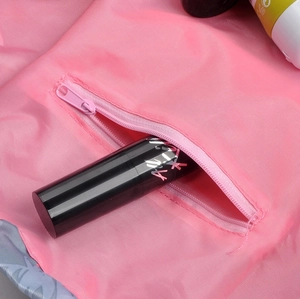 Pink drawstring cosmetic bag detail, portable travel makeup storage pouch with zipper pocket.