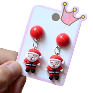 Detail of Christmas Santa Claus drop earrings with red spherical backs held by hand