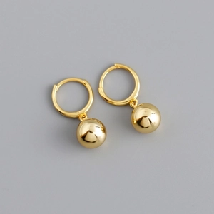 Detailed view of polished golden hoop earring with a sleek spherical metal drop pendant