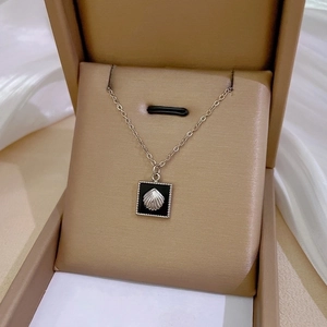 Macro detail of silver geometric square pendant with shell inlay on titanium steel chain