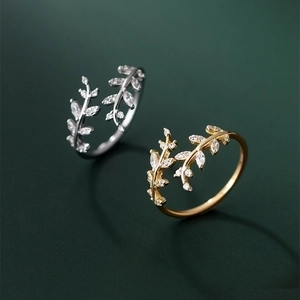 Detail of silver and gold leaf-shaped open rings set with micro-pave cubic zirconia