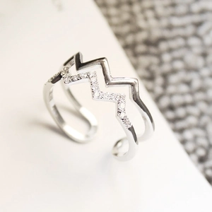 Macro detail of a double-layered wavy silver ring with pavé-set sparkling zircons