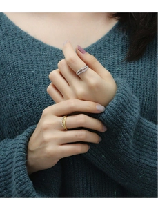 Detail of stacked gold and silver rings with pave-set cubic zirconia on hands