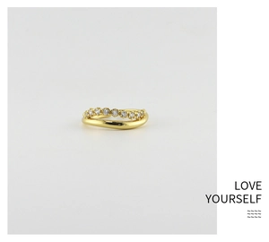 Macro shot of wavy gold plated S925 silver ring featuring sparkling zircon gemstones