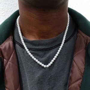 Elegant white 8mm round faux pearl necklace worn by a model in casual outdoor setting