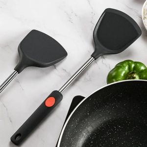 Silicone kitchen spatula detail showing black heat-resistant turner head and stainless steel handle.