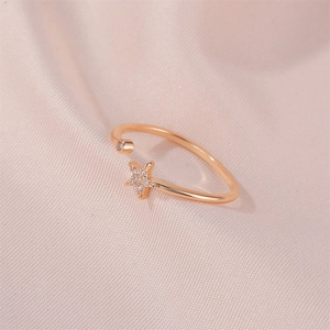Minimalist adjustable star ring with zircon inlay on a soft pink silk background