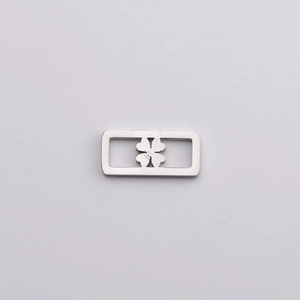 Macro shot of silver stainless steel rectangular pendant with hollow clover pattern detail